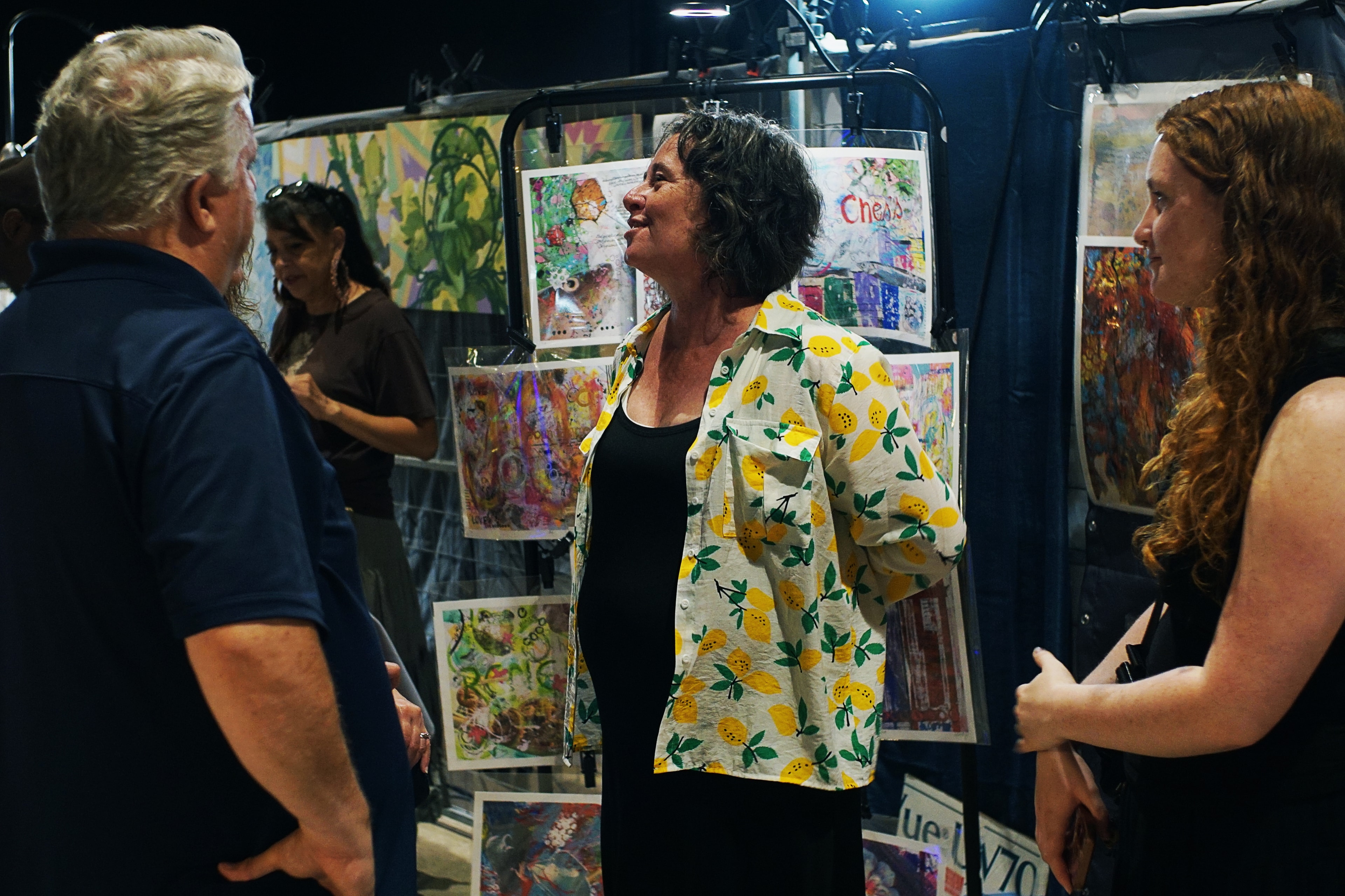Dana Corkey discussing artwork with visitors at gallery